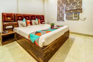 una camera con un grande letto con struttura in legno di FabExpress Affection Inn a Lucknow