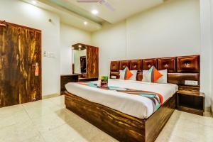 una camera con un grande letto con testiera in legno di FabExpress Affection Inn a Lucknow