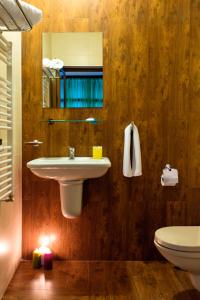 a bathroom with a sink and a toilet and a mirror at Family Hotel BOHEMA in Ognyanovo