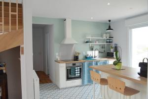 une cuisine avec une cuisinière et une table à l'intérieur dans l'établissement VILLA KEREZAM au petit port de Mogueriec, à Sibiril