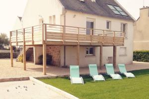 un groupe de chaises posées sur l'herbe devant une maison dans l'établissement VILLA KEREZAM au petit port de Mogueriec, à Sibiril