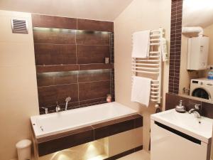 łazienka z wanną i umywalką w obiekcie Apartament Kleopatra w Limanowej