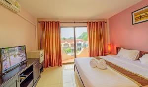 1 dormitorio con 2 camas, TV y ventana en Mukanda Residence, en Ao Nang Beach