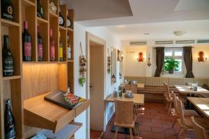 a restaurant with tables and chairs and wine bottles at Landgasthof Mörsbergei in Bubenreuth