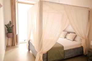 a bedroom with a canopy bed with a window at La Guarida Suites in Barcelona