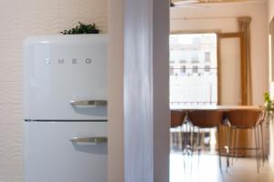 a white refrigerator in a kitchen with a table at La Guarida Suites in Barcelona