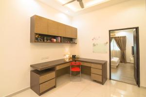 Landed Cozy House Near SPICE, Airport في Kampong Manggis: مكتب منزلية مع مكتب وكرسي احمر