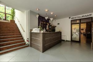 a restaurant with a counter and stairs in a building at Family Hotel BOHEMA in Ognyanovo