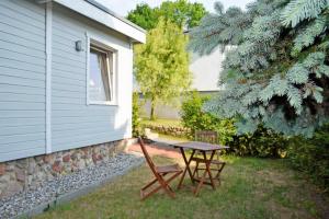 a picnic table and two chairs next to a house at Ferienbungalow in Goehren in Göhren