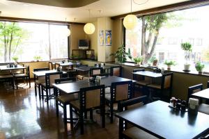 een eetkamer met tafels en stoelen in een restaurant bij Hotel Route-Inn Court Nirasaki in Nirasaki
