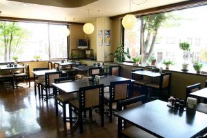 a dining room with tables and chairs in a restaurant at Hotel Route-Inn Court Nirasaki in Nirasaki