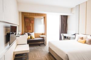 a hotel room with a bed and a couch at twothree a homely hotel - SHA Extra Plus in Bangkok +50 photos