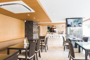 a restaurant with tables and chairs and a flat screen tv at twothree a homely hotel - SHA Extra Plus in Bangkok