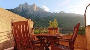 a table and two chairs on a balcony with mountains at Résidence A Barcella in Porto Ota