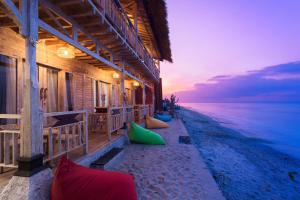 ein Haus am Strand mit Sonnenuntergang im Hintergrund in der Unterkunft The Dewi Sun Sun Suite in Nusa Penida