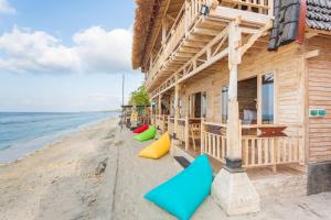 a wooden house on the beach with colorful pillows at The Dewi Sun Sun Nusa Penida in Nusa Penida