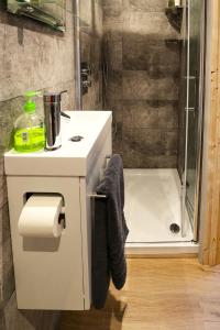 a bathroom with a white sink and a shower at Wimpenny Place in Holmfirth