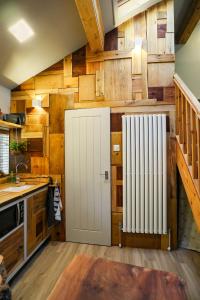 a kitchen with a white radiator and wooden walls at Wimpenny Place in Holmfirth