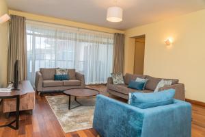 a living room with two couches and a table at Valley Arcade Towers - Kilimani in Nairobi