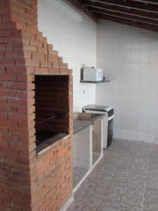 a brick oven in a kitchen with a brick wall at Chalé Excelente Localização in Ubatuba