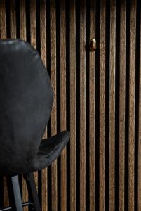 Hotel Medi في Ikast: كرسي أسود جالس أمام الجدار
