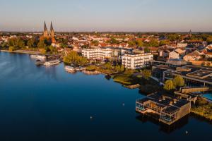 une vue aérienne sur une ville avec une grande étendue d'eau dans l'établissement Resort Mark Brandenburg & Fontane Therme, à Neuruppin