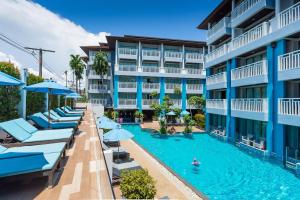 uma imagem de um hotel com piscina e guarda-sóis em Blue Tara Hotel Krabi Ao Nang em Praia de Ao Nang