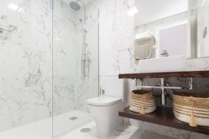 a white bathroom with a toilet and a shower at Apartamento Puertoplaya II in Puerto de Mazarrón +51 photos