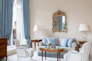 uma sala de estar com um sofá, cadeiras e um espelho em Le Bristol Paris - an Oetker Collection Hotel em Paris