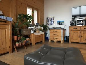 sala de estar con sofá de cuero y TV en Chalet du bois des Fugiers en Ugine