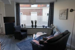 un soggiorno con divano, tavolo e finestra di Studio 82 a a Middelburg