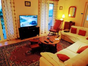 een woonkamer met een bank en een tv bij Gythio Seaside Villa Dimitrios - Panoramic View in Gythio