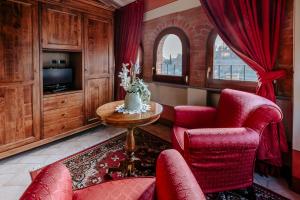 een woonkamer met rode stoelen en een tafel bij Dimora Casa Eugenia in Loro Ciuffenna