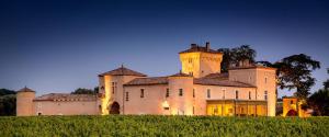 un antiguo castillo con una torre en lo alto de un campo en Château Lafaurie-Peyraguey Hôtel & Restaurant LALIQUE en Bommes