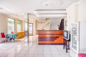 een lobby met een piano en een tafel en stoelen bij RedDoorz near XT Square 2 in Yogyakarta