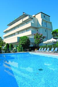 a hotel with a swimming pool in front of a building at Hotel Old River in Lignano Sabbiadoro