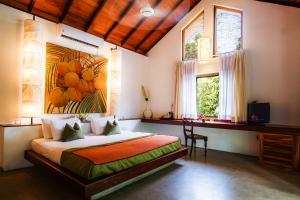 1 dormitorio con 1 cama con una pintura en la pared en Sigiriana Resort by Thilanka en Dambulla