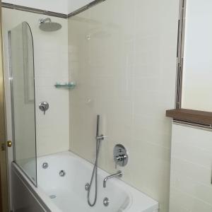 uma casa de banho com um chuveiro e uma banheira em Hotel Bristol em Milão
