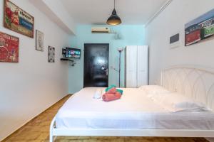 a bedroom with a white bed with a stuffed animal on it at Cozy Studio near Downtown in Heraklio