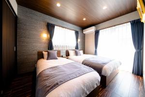 a bedroom with two beds and a window at 22 ORIYA Mt Fuji -錦NISHIKI- in Fujikawaguchiko