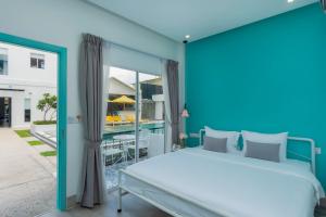 a bedroom with a large bed and a balcony at Glow Inn Siem Reap in Siem Reap