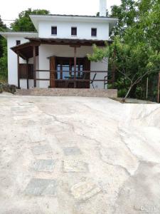 a small white house with a large stone patio at Villa Annoula in Pouríon