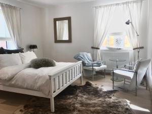 a bedroom with a white bed and a chair and window at The Acorns in Marlow