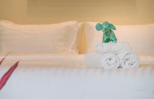 Aonang Eco Villa - SHA Extra Plus في شاطيء آونانغ: لعبة الفيل تجلس فوق المناشف على السرير