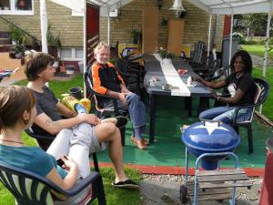 eine Gruppe von Menschen, die auf Stühlen um einen Tisch sitzen in der Unterkunft Bergsvägen Bed & Breakfast in Urshult