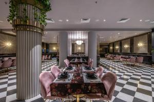 a dining room with a table and pink chairs at Clarks Inn Suites Raipur in Raipur