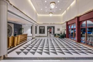 eine Lobby mit schwarz-weiß kariertem Boden in der Unterkunft Clarks Inn Suites Raipur in Raipur