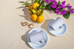 une table avec deux assiettes et un vase avec des fleurs violettes dans l'établissement Apartments Jadranka, à Privlaka