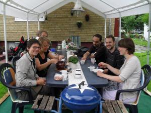 um grupo de pessoas sentadas à mesa em Bergsvägen Bed & Breakfast em Urshult