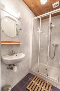 a bathroom with a shower and a sink and a mirror at Giffre et Clesson in Samoëns